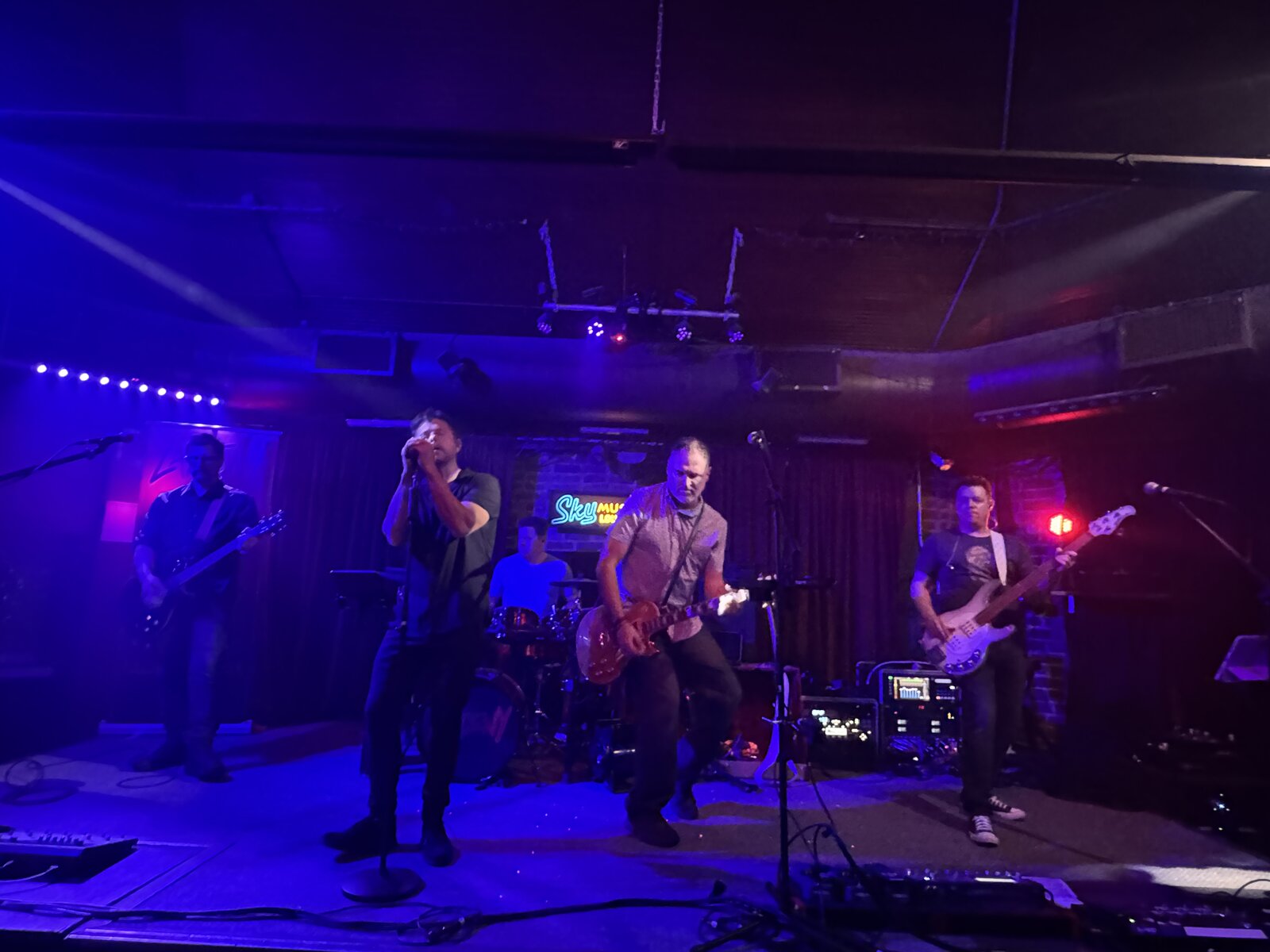 Larceny full band on stage at Sky Music Lounge with blue and purple lighting