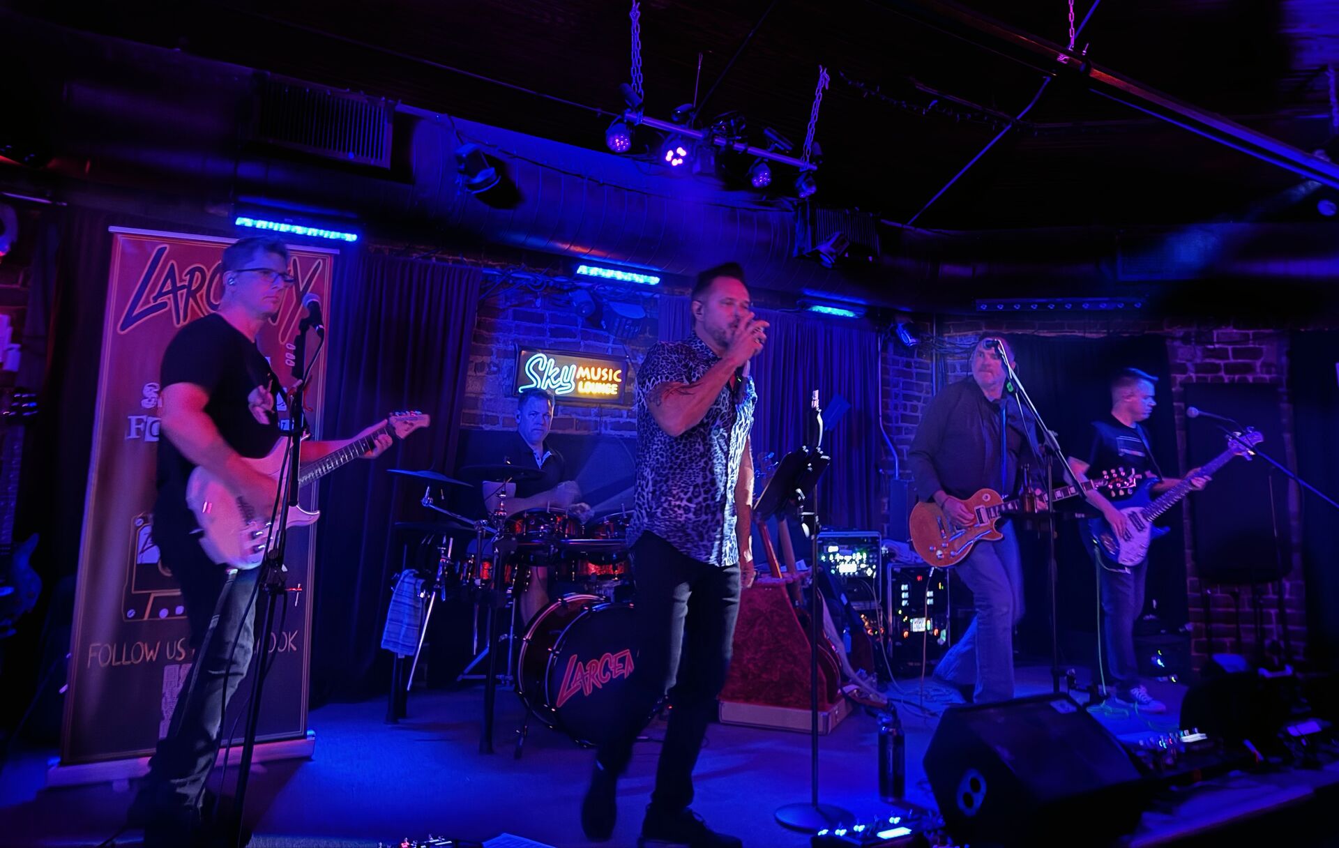 Larceny on stage at Sky Music Lounge with blue lighting